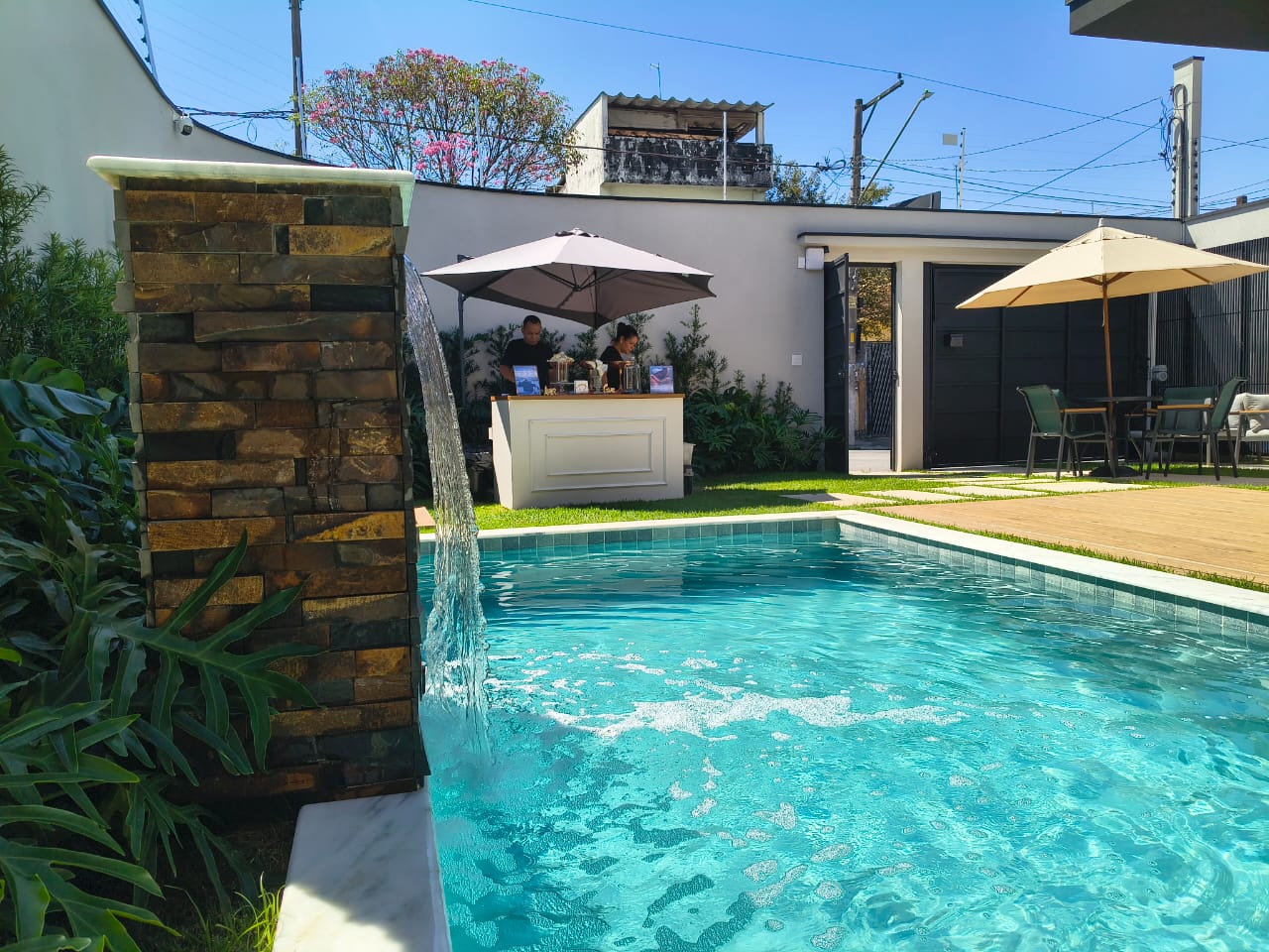 Piscina com cascata e bar de apoio durante o dia