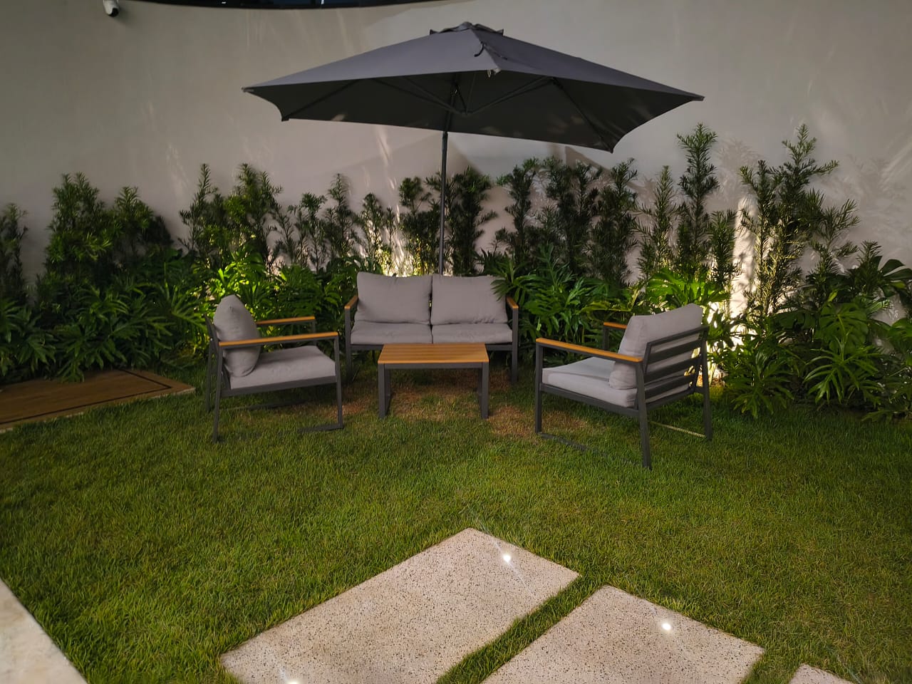 Lounge externo com sofás e ombrelone