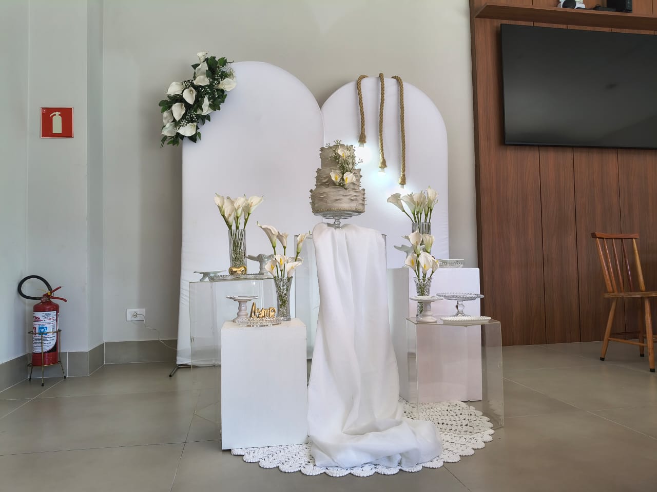 Mesa do bolo decorada com flores brancas e bolo de três andares